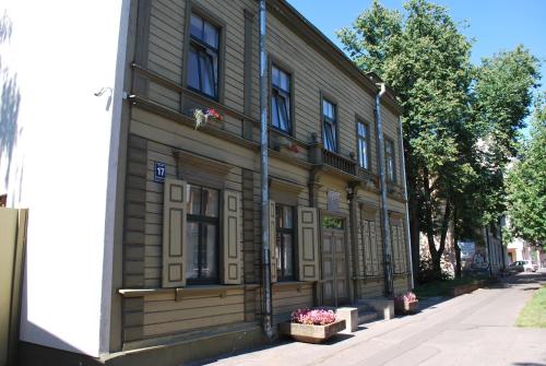 un antico edificio in legno sul lato di una strada di Muzeja apartamenti a Riga