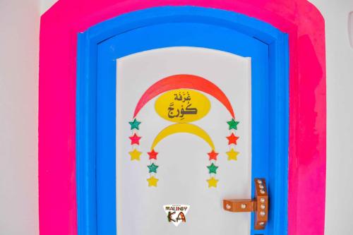 a colorful door with a rainbow and a sign on it at malindy KA ماليندى كا in Aswan
