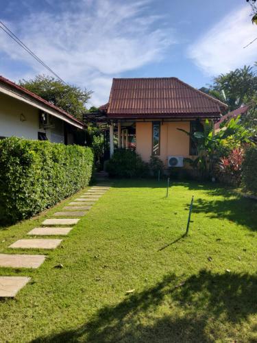 a house with a lawn in front of a house at LANTA LUCKY HOUSE in Ko Lanta