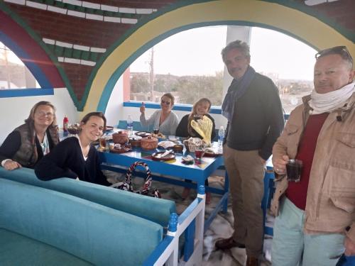 a group of people standing around a table with food at malindy KA ماليندى كا in Aswan