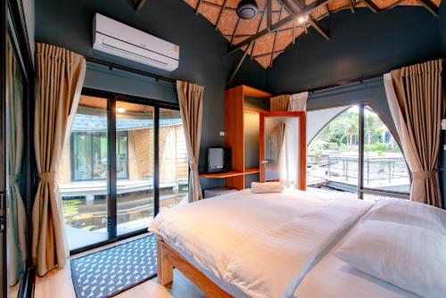 a bedroom with a large bed with a large window at Turtle Bay Eco Luxe Hua Hin in Khao Tao