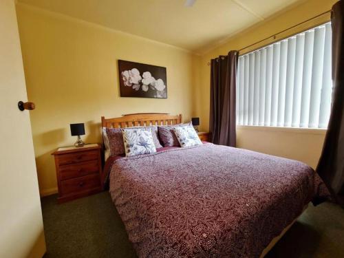 a bedroom with a large bed and a window at Ahuriri Escape - Home Away Home, Entire Bungalow in Napier