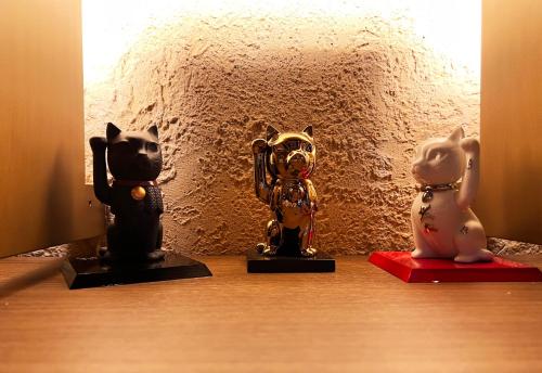 three statues of cats and a dog on a table at yoin hotel kyoto gion in Kyoto