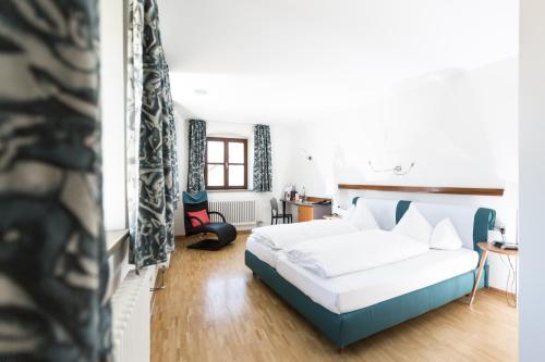 sypialnia z białym łóżkiem i biurkiem w obiekcie Hotel Klostergasthof w mieście Thierhaupten