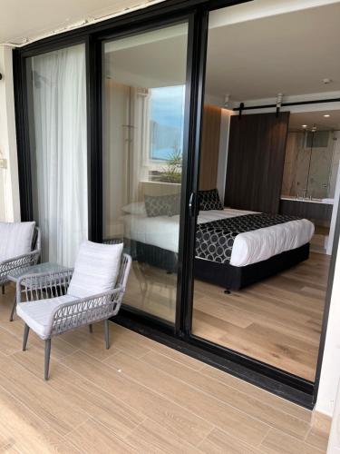 a bedroom with a bed and a mirror at Ocean Front Motel in The Entrance