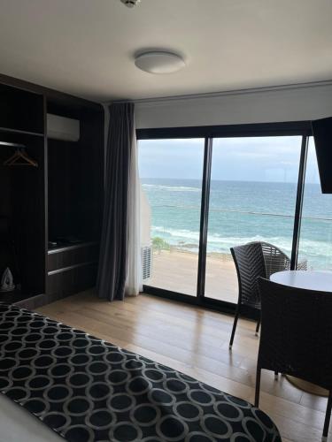 a bedroom with a view of the ocean from a beach at Ocean Front Motel in The Entrance