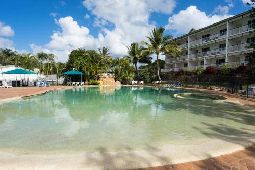 a large swimming pool in front of a hotel at K'gari Beach Resort in Fraser Island