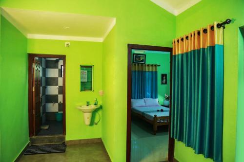 uma casa de banho com paredes verdes e uma casa de banho com um lavatório. em Puzhayoram home stay, Palakkuli, Mananthavadi wayanad kerala em Mananthavady