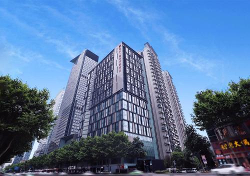 un edificio alto con muchas ventanas en una calle de la ciudad en Rhombus Park Aura Chengdu Hotel, en Chengdú