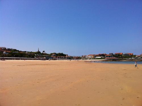 a person flying a kite on a sandy beach at Marina de Campios in Comillas