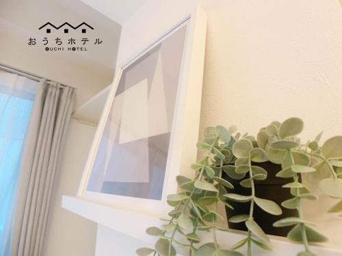 a plant in a vase next to a window at OUCHI HOTEL Fujimi in Hiroshima