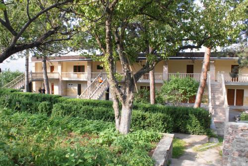a house with a tree in front of it at Odzun Hotel in Alaverdi