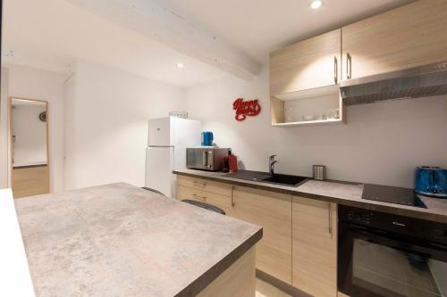 une cuisine avec un réfrigérateur blanc et un plan de travail dans l'établissement Brand-new atypical studio in rue Fourmillière, à Antibes