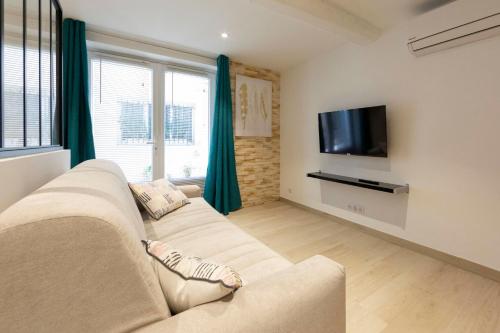 un salon avec un canapé et une télévision à écran plat dans l'établissement Brand-new atypical studio in rue Fourmillière, à Antibes