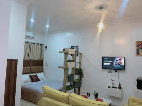a room with a bedroom with a bed and a tv at Cozy studio unit in lekki phase 1 - Kitchen, 24-7 light, wifi, Netflix in Lagos