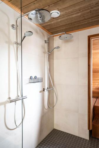 a bathroom with a shower with two lights on the ceiling at Villa Ruka - Rising Sun with 3 bedrooms, loft, sauna and balcony with a view in Ruka