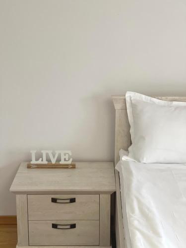 a bed with a nightstand with a clock on it at La Mimi Villa in Sadu