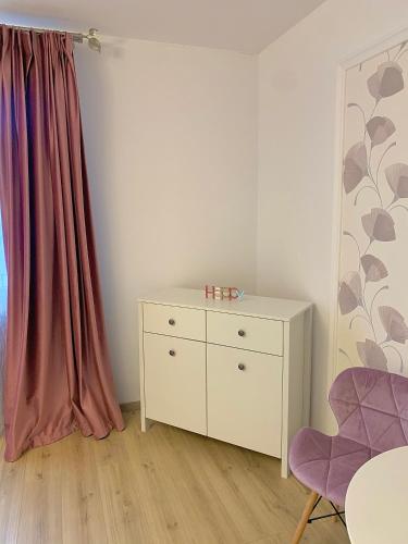 a room with a white dresser and a curtain at La Mimi Villa in Sadu