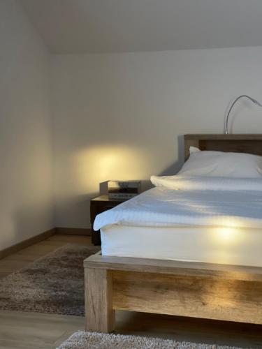 a bedroom with a bed and a nightstand with a white bedspread at La Mimi Villa in Sadu