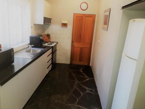 a kitchen with a counter and a sink and a refrigerator at Mintaro Hideaway in Mintaro