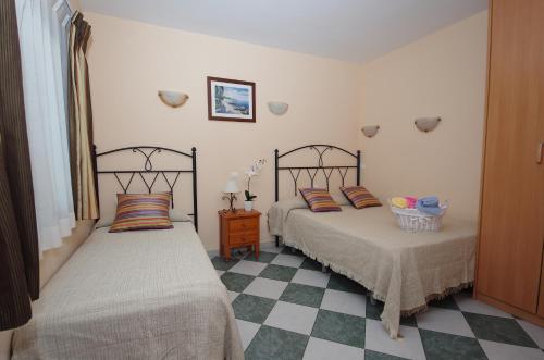 マルベーリャにあるPensión Aduarのベッドルーム1室(隣り合わせのベッド2台付)