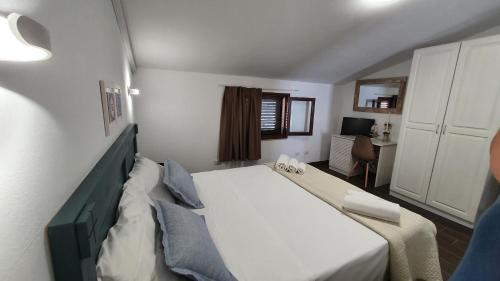 a small bedroom with a bed and a desk at Apartment in a villa a stones throw from the sea in Fontane Bianche