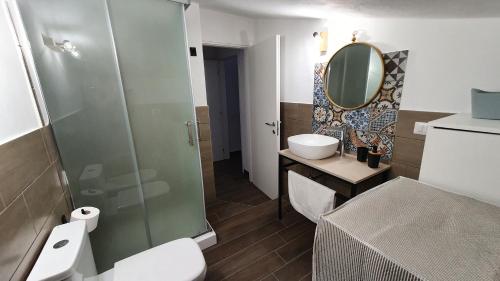 y baño con aseo, lavabo y espejo. en Apartment in a villa a stones throw from the sea, en Fontane Bianche