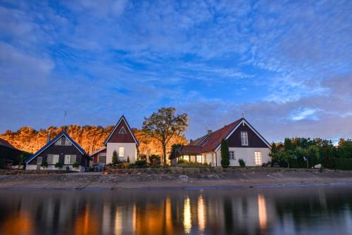 a row of houses next to a body of water at Vila Preiloja in Neringa