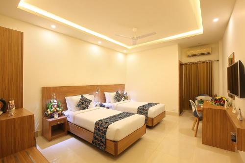 PathanāmthittaにあるHotel Heydayのベッド2台とテレビがあるホテルの部屋