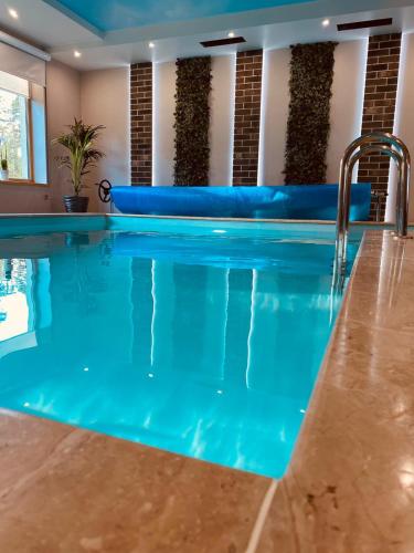 a swimming pool with blue water in a hotel room at Irbēni in Brivkalni