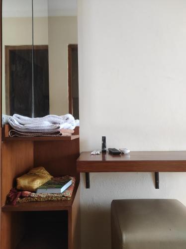 a room with a shelf with books and a mirror at Adiputra Guesthouse Tata Bumi in Ngabean