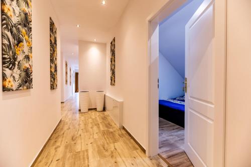 a hallway with white walls and wood floors and a door at Apt FIONA4 Centrum700m Parking Prywatny Bezpłatny in Karpacz
