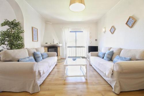 a living room with a white couch and a table at E&M Garden View Beach House VII in Porches