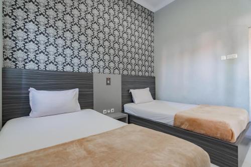 Postel nebo postele na pokoji v ubytování Hotel Markoni Pamanukan Mitra RedDoorz