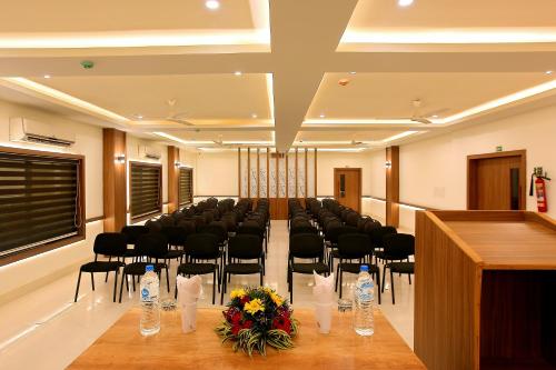 a conference room with a long table and chairs in it at Hotel Heyday in Pathanāmthitta