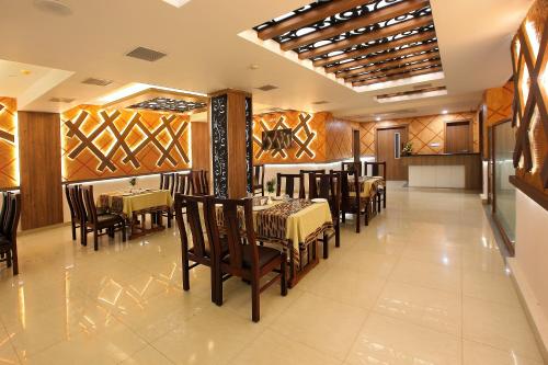 a dining room with tables and chairs in a restaurant at Hotel Heyday in Pathanāmthitta