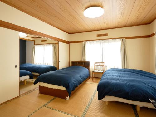 a bedroom with three beds in a room at LY INN CHITOSEAIPORT - Vacation STAY 94792 in Chitose