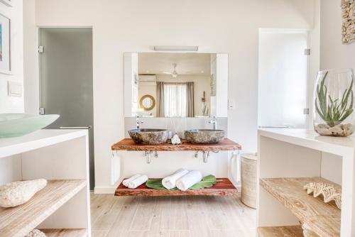 Baño con 2 lavabos y espejo en Pineapple Beach Villas en Baie Lazare Mahé