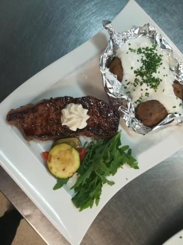 a plate of food with meat and vegetables on it at Hotel Kleißl in Oberperfuss