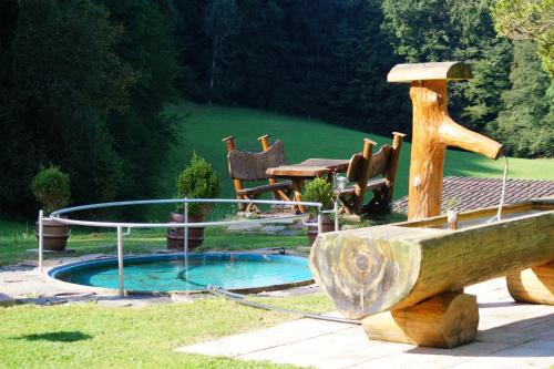 una pequeña piscina con un barco de madera y una mesa en Gästehaus Schmuckenhof en Marktschellenberg