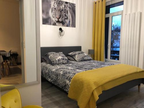 a bedroom with a bed and a picture of a tiger at La maison d’Alice in Aix-les-Bains