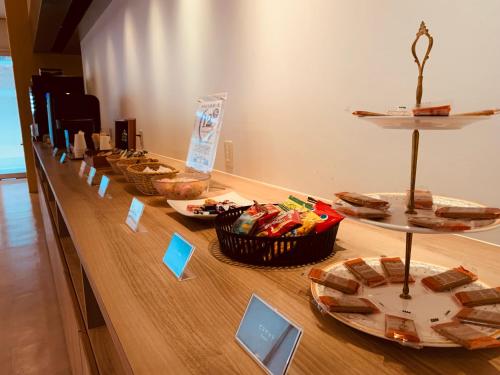 a long wooden table with plates of food on it at Hotel Tenjin Place in Fukuoka