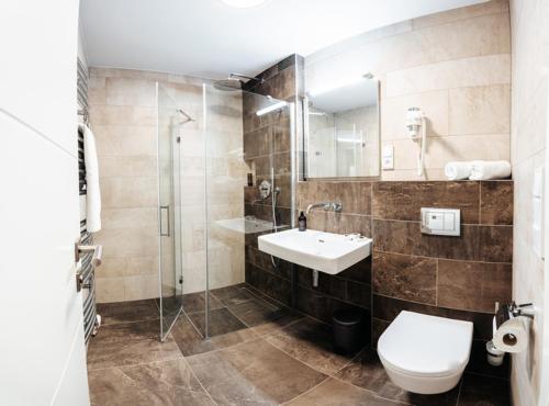 a bathroom with a toilet and a sink and a shower at Beachwell in Pelhřimov