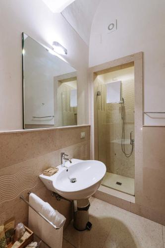 a bathroom with a sink and a shower with a mirror at Santa Rosa Relais in Noci
