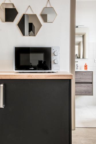 un micro-ondes posé sur un comptoir dans une cuisine dans l'établissement Centre - Le Contemporain - Parking, à Drulingen