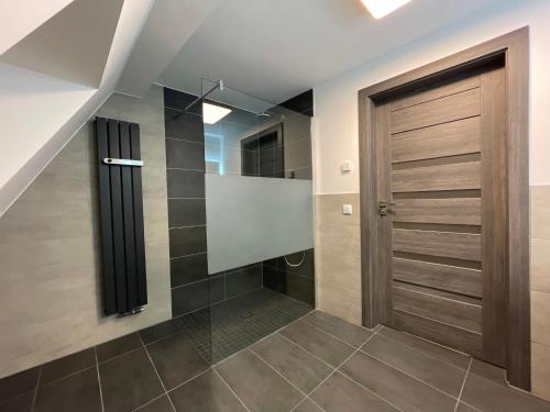 a bathroom with a wooden door and tile floors at Alter Kornspeicher in Havelberg