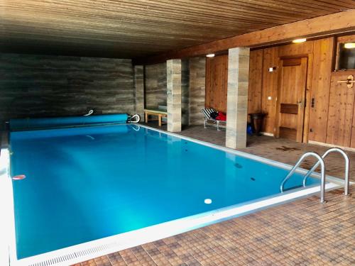 a large swimming pool in a room with at Haus Wenger Mountain View & Swimming Pool in Kaprun