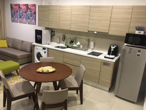 a kitchen with a table and a small kitchen with a table and chairs at i-Suite, i-City by Mohas Homes in Shah Alam