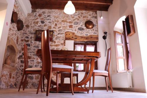 a dining room with a wooden table and chairs at The Old House Cottage in Malia