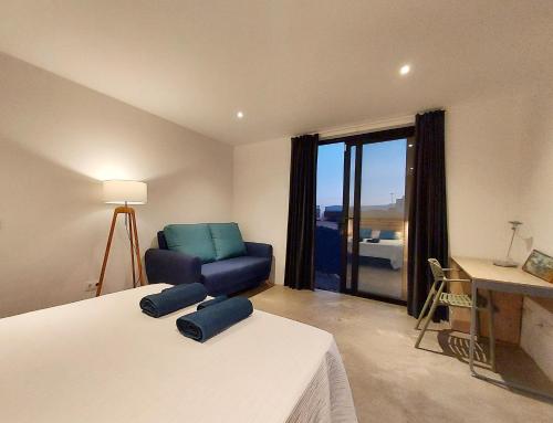ein Schlafzimmer mit einem Bett und einem Stuhl und einem Fenster in der Unterkunft Villa Tabaiba en Lajares con Piscina in Lajares